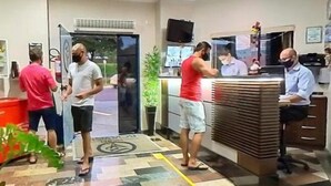 Zona de recepción con mostrador, una planta y puerta que da al exterior.