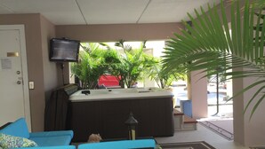 A lobby area with a seating area, a television mounted on the wall, and a view of the outside.
