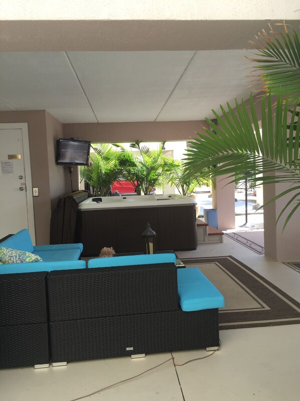 A lobby area with a seating area, a television mounted on the wall, and a view of the outside.