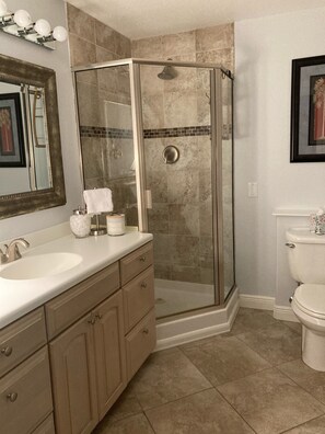 A bathroom with a glass-enclosed shower, a sink with a vanity, and a toilet. - Views ~ Pool~Private Hot Tub~FREE Boat Slip~Heaven!!! (Marathon)
