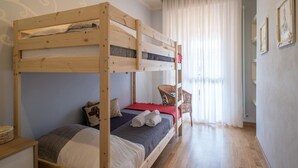 A bunk bed room with a window, a chair, and a wall with framed pictures. - La Vue Sur La Mer Beach House (Viareggio)