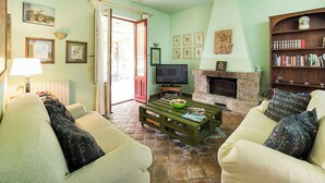 Ein Wohnzimmer mit Kamin, Fernseher und Bücherregal.