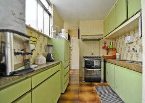 A compact kitchen with green cabinets, a stove, an oven, a sink, and a blender. - LineRio Copacabana Family Residence 346 (Rio de Janeiro)