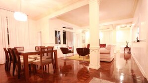 A spacious living room with a wooden dining table and chairs, a sofa, and a large window. - LineRio Copacabana Family Residence 346 (Rio de Janeiro)