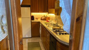 Una cocina con armarios de madera, un refrigerador, un fregadero y una estufa.