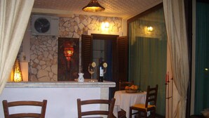 Ein gemütlicher Essbereich mit Steinwand, einer Bar und zwei hölzernen Stühlen.