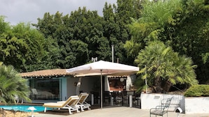 A backyard with a pool, lounge chairs, and a barbecue area. - Rural farm Enjoy nature and feel the silence (Palmela)