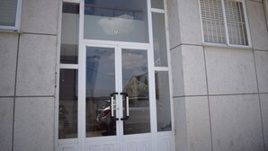 A building facade with a large glass window, a door with a number "12" above it, and a ventilation grille on the right side. - Studio Penthouse La Casa de Manuel, is located in Portomarín, 22km from Sarria. (Portomarín)