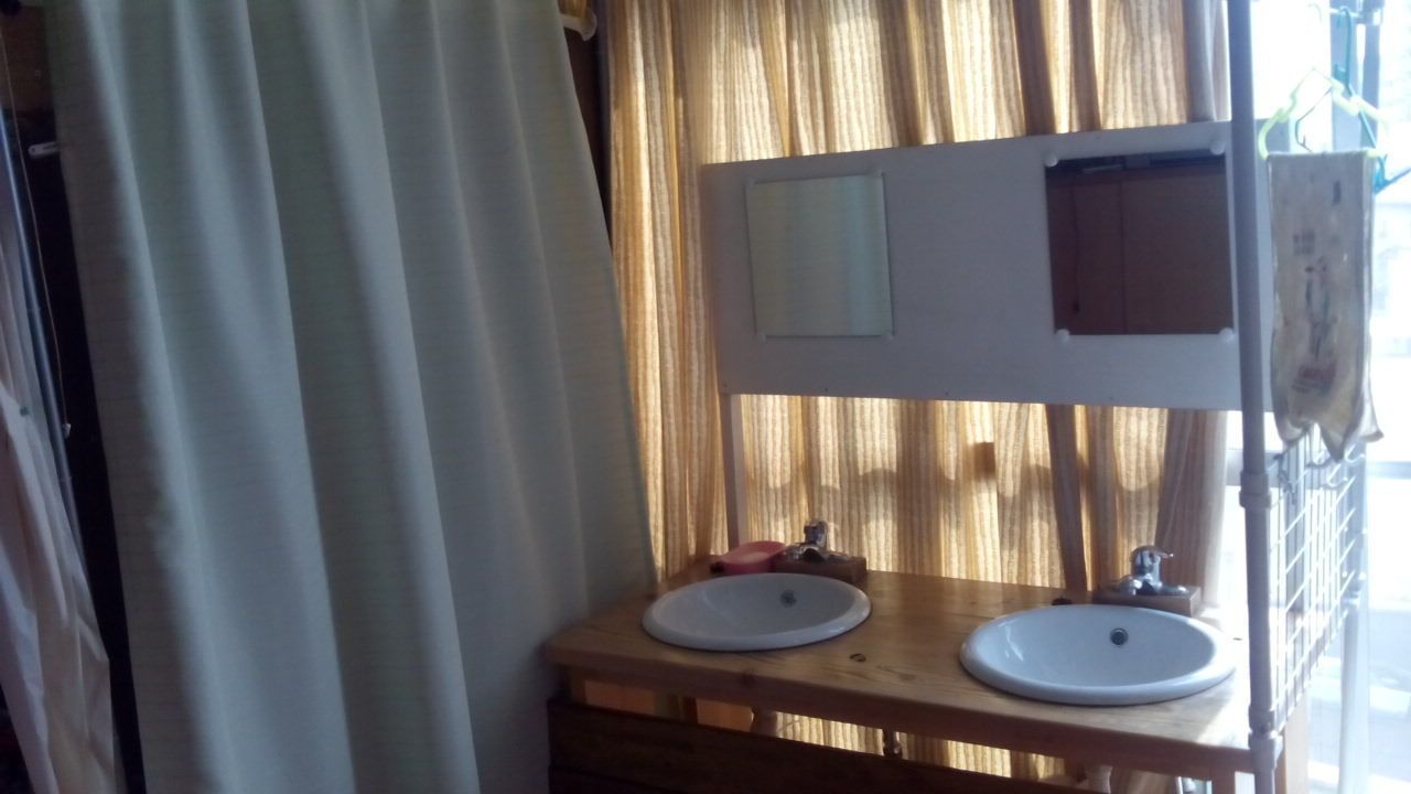 Une salle de bain avec deux lavabos, un miroir et un meuble-lavabo en bois.