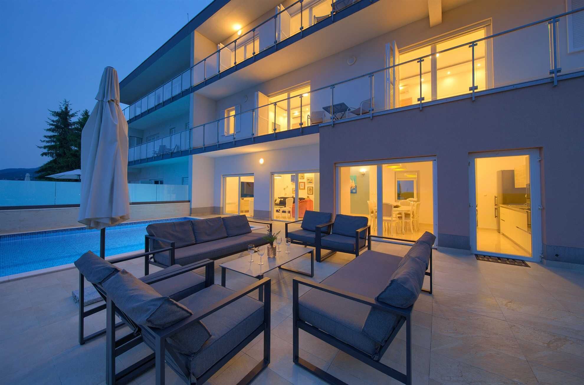 A multi-story building with a pool, outdoor seating, and balconies.