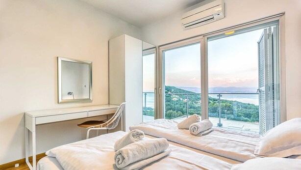 A hotel room with two beds, a desk, a chair, a large window with a view, and an air conditioning unit. - Villa Sole - five bedrooms with sea views and a private pool by MyWaycation (Poljane)