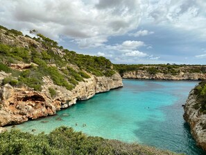 A coastal landscape with rocky cliffs and clear turquoise water. - In 1st sea line with great sea view, 4 minutes walk to the beach, air conditioning, heating (Cala Murada)