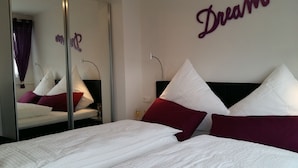 Una habitación de hotel con una cama, un espejo y una pared con la palabra 'Dream'.