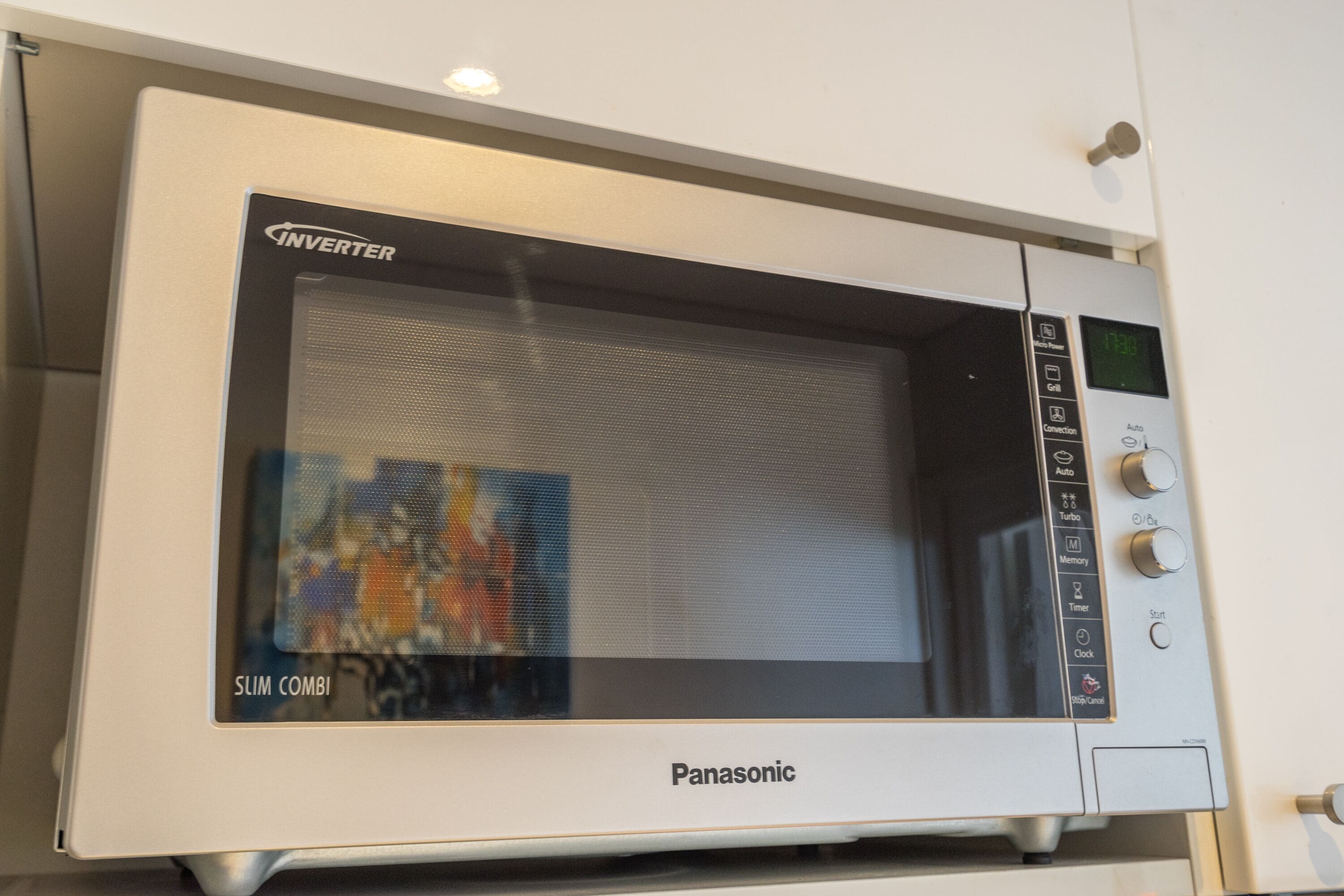 Un horno microondas Panasonic con pantalla digital y varios botones de control.