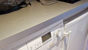 A front-loading Siemens washing machine with a control panel, a wooden countertop, and various kitchen items. - HISTORIC CENTER St. Germain-Près—close to the metro, the river, shopping, comfortable, quiet, and bright (Paris)