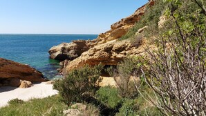Un paysage côtier caractérisé par des falaises rocheuses, une végétation clairsemée et une vue dégagée sur la mer.