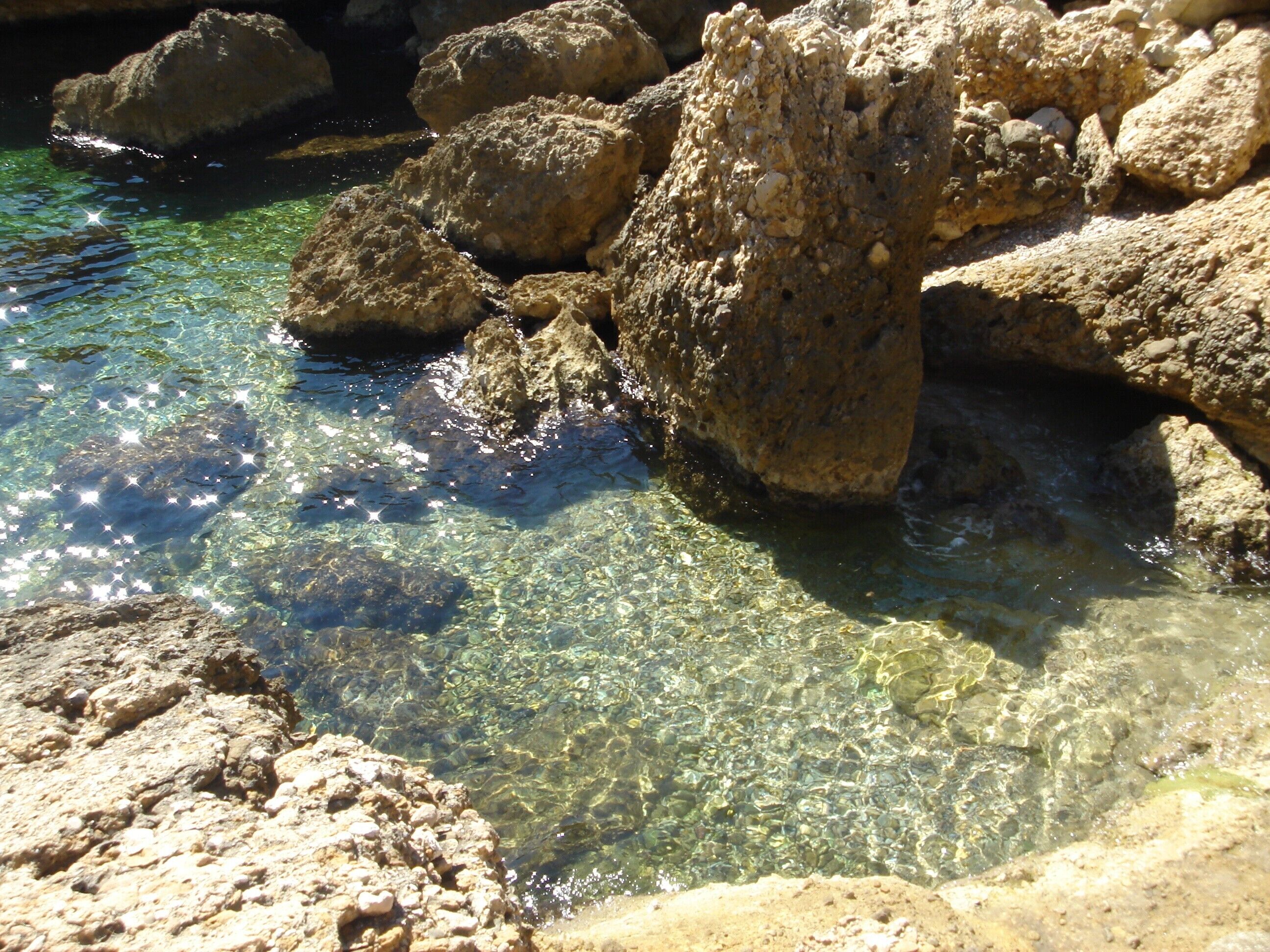 Eine felsige Küstenlinie mit klarem Wasser.