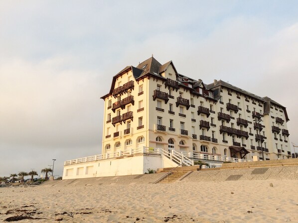 Een groot, meerijlaags hotel met balkons en een trap naar de ingang.