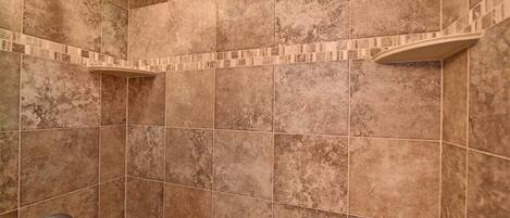 A shower area with tiled walls and a showerhead.