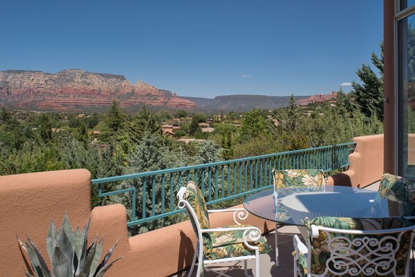 Ein Balkon mit Tisch und Stühlen mit Blick auf eine Berglandschaft.