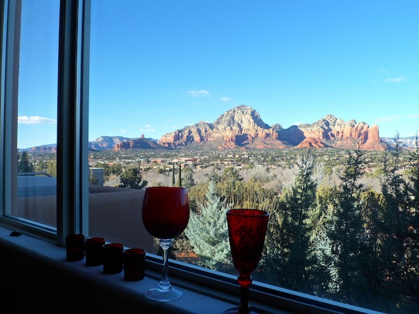 A window with a red wine glass and two red cups on a windowsill, overlooking a mountainous landscape with a clear sky. - RARE FIND! Star of Sedona Villa on Vortex Land+ Red Rock Views + Stunning Deck! (Sedona)