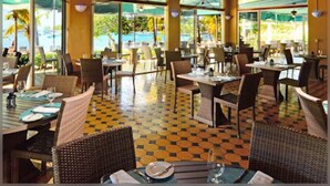 Ein Restaurant mit hoher Decke, großen Fenstern und einem Schachbrettfußboden.