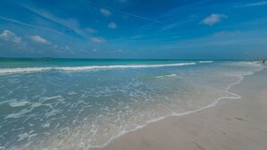 Ein Strand mit klarem, blauem Wasser und sandigem Ufer.