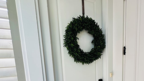 A white door with a wreath, a doorknob, and a black mat at the entrance. - Studio Near the Plantations (Charleston)
