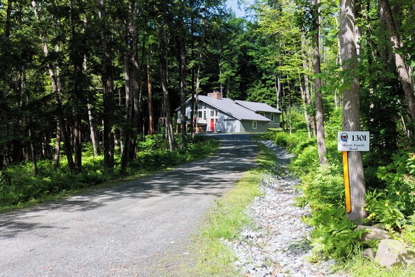 A house with a red door and a sign indicating 'Marsh Family Road.'