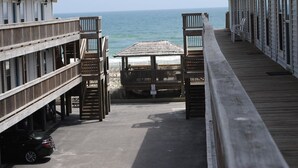 Une jetée en bois qui mène à une plage d’où l’on peut admirer l’océan.