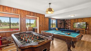 A room with a foosball table, pool table, and a television. - Private Hot Tub! Game Room! Close to Slopes! Bright & open Amazing Views! (Big Bear City)