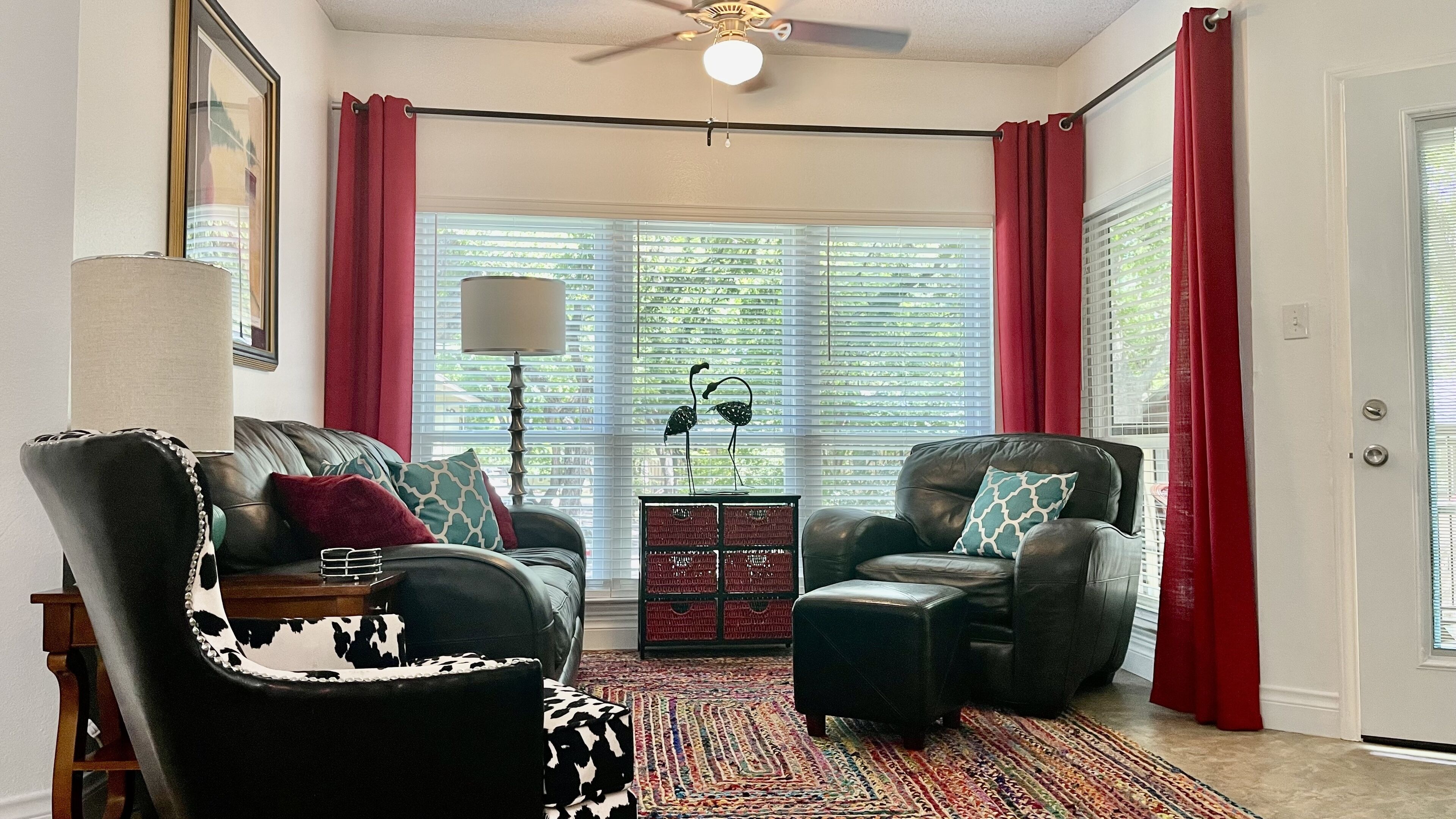 A living room with two leather sofas, a patterned rug, and a decorative lamp.