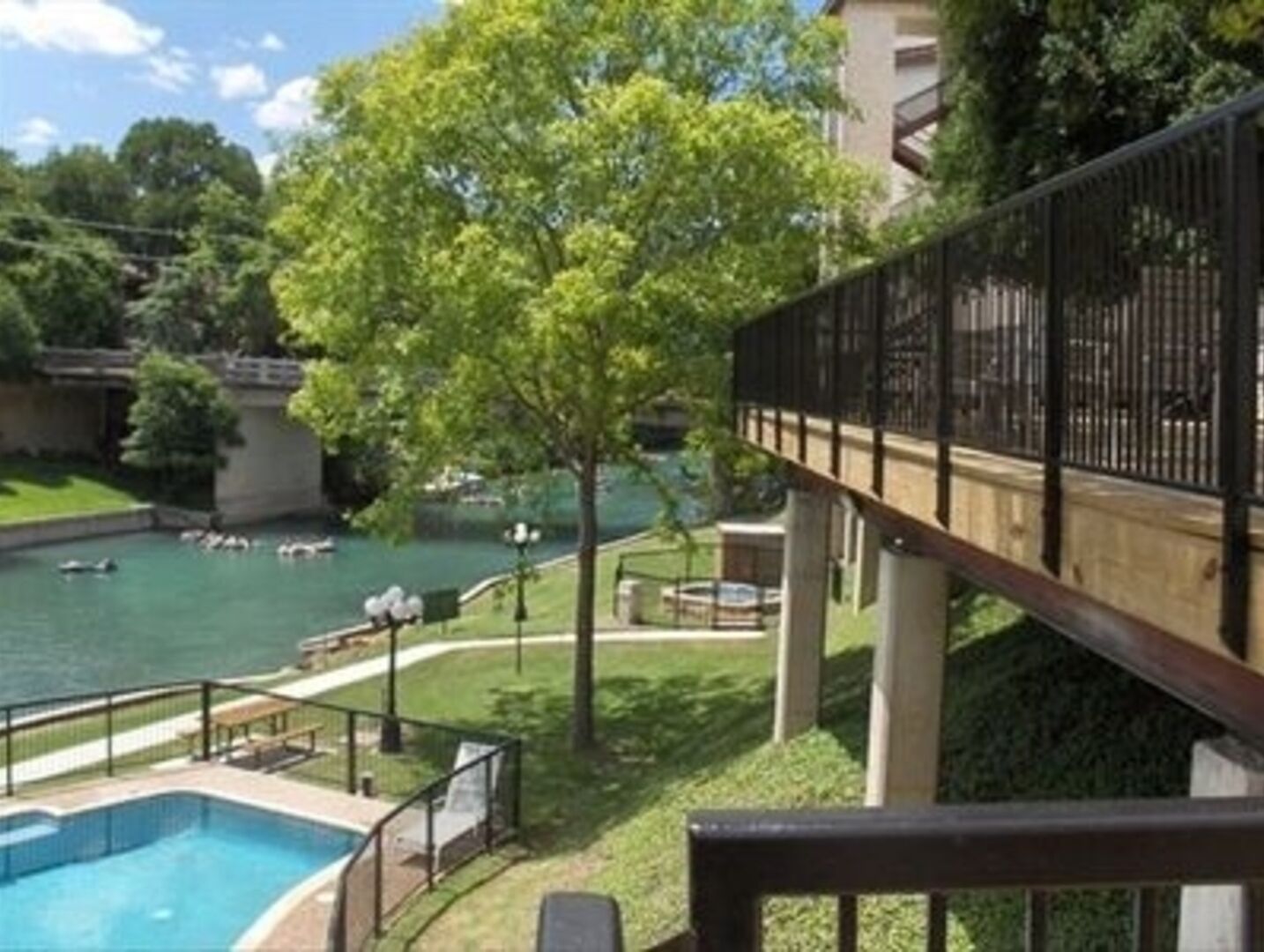 Ein Schwimmbecken mit Holzboden und Blick auf einen Fluss.