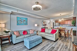 A modern living room with a sofa, ottoman, and dining area. - UP TO 50% OFF RESORT Spectacular 5-Star Luxury Direct Oceanfront 3B/3Ba Condo (Myrtle Beach)