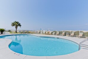 A swimming pool with a white fence, lounge chairs, and a palm tree. - Gulf Shores Plantation Resort 4307 (Gulf Shores)