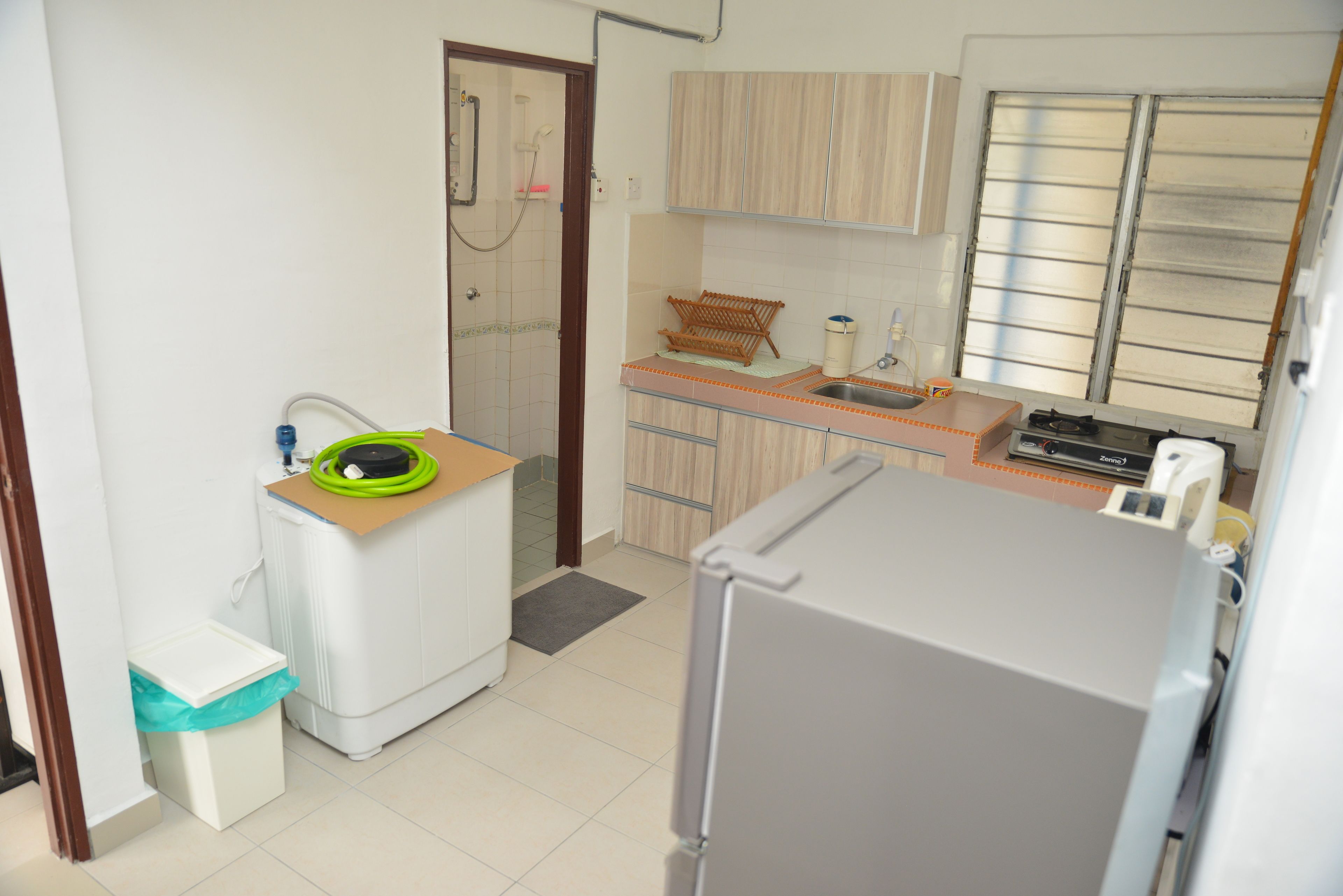 A compact kitchen with a refrigerator, sink, and a small countertop.