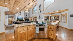 Una cocina amplia con armarios de madera, una isla central y una estufa grande.