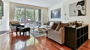 A modern living room with a sofa, coffee table, and a black cabinet. - Modern open concept, close to DT and Free UG Parking. Discounted Monthly Rate. (Calgary)