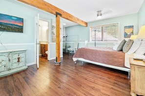 Un dormitorio con cama, cómoda, escritorio y ventana con persianas.