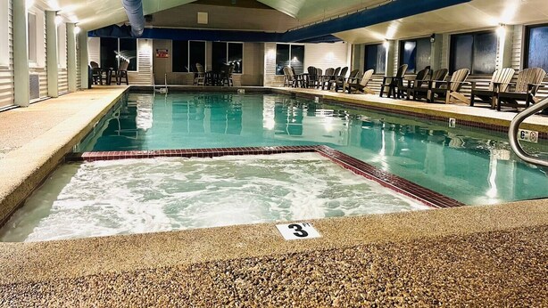 Une piscine intérieure dotée d’un sol en galets, de chaises longues et d’un poste de surveillance pour les sauveteurs.
