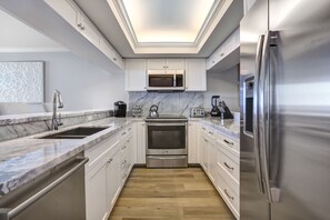 Enjoy cooking and coffee preparation in this well-equipped kitchen with a double sink and stainless steel appliances.