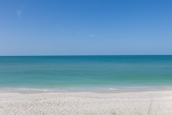 En strand med klart turkis vand og hvidt sand.