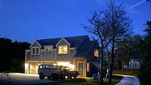 A two-story house with a garage, a driveway, and a tree in front. - Madaket Beach House- Walk to Beach- Private Nantucket Home. (Nantucket)