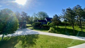 A residential area with a house, a gravel driveway, and surrounding greenery. - Madaket Beach House- Walk to Beach- Private Nantucket Home. (Nantucket)