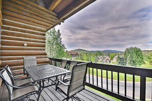 Enjoy a serene view of the surrounding houses and mountains from this deck with a table and chairs.