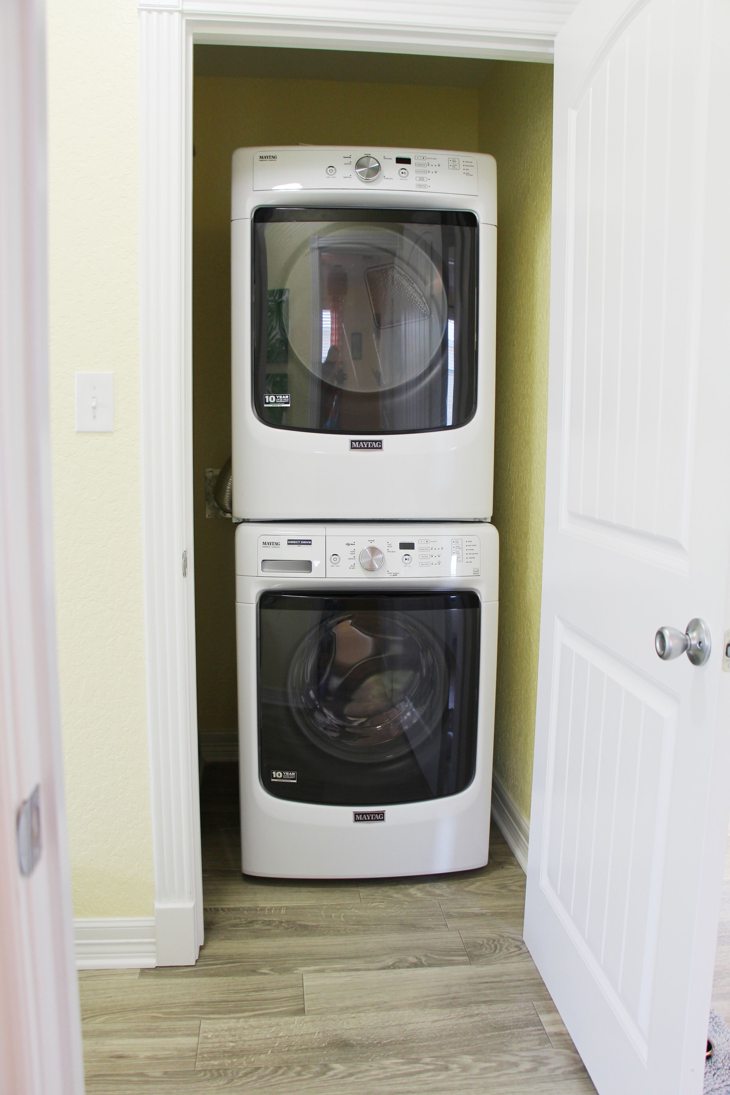 A laundry room with two stacked front-loading washing machines.