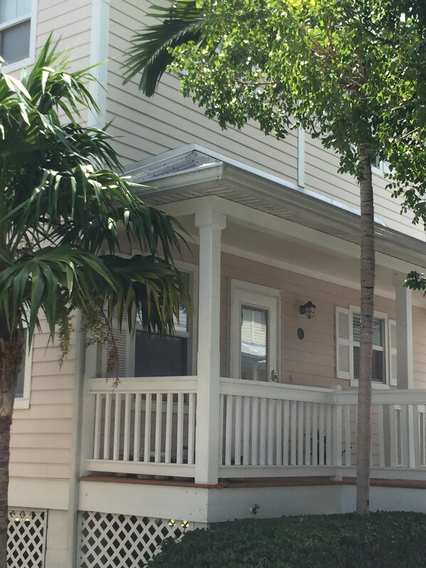 A two-story house with a porch, a small window, and a door.