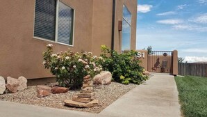 A building with a stucco exterior, a large window, and a gated entrance.