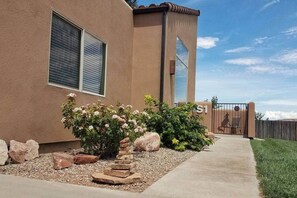 A building with a stucco exterior, a large window, and a gated entrance.