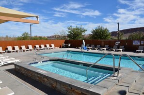 A pool area with multiple lounge chairs and a lifeguard station. - 3 KING BEDS with Rim Views Near Arches > Pool Hot Tub and Adventures (Grand County)